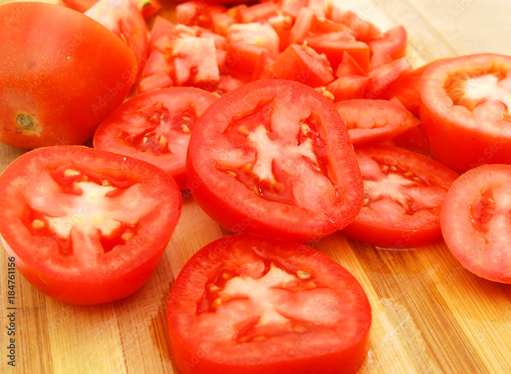 Red tomato slices on chopping board
