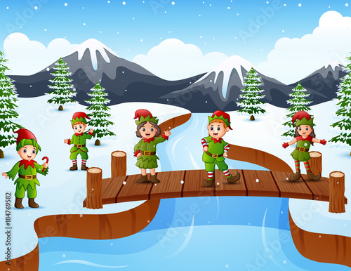 Happy kid wearing elf costume on the bridge in the snowing hill