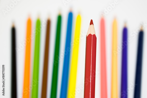 A lots of color pencil on white background, focus at red pencil color
