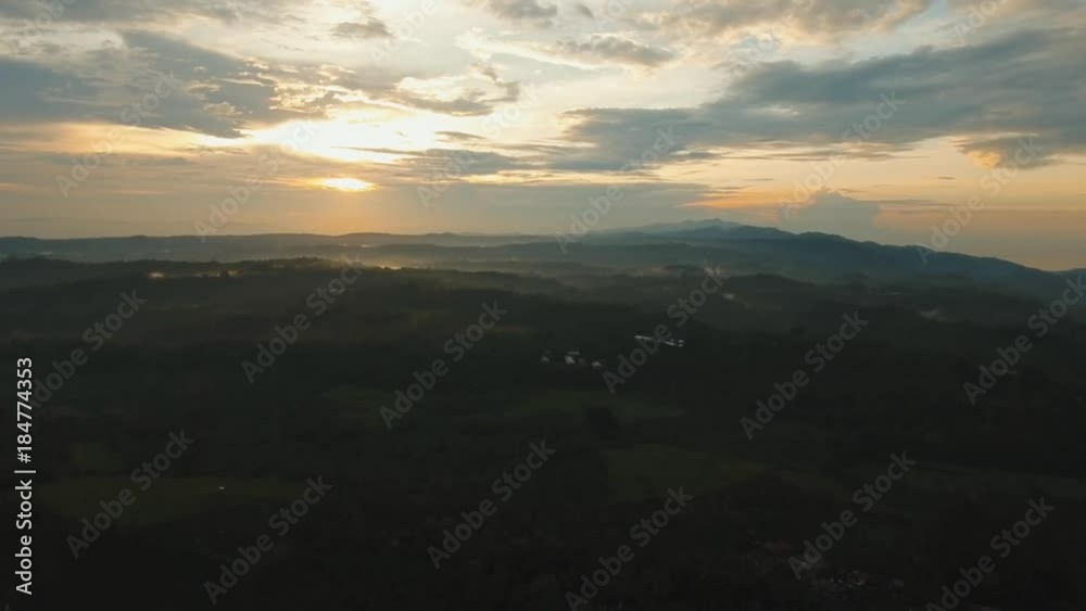 Aerial view of forest, mountains with fog, clouds at sunset on Bali,Indonesia. Tropical rainforest, trees, jungle in mountains. Fog over the jungle. Travel concept. Aerial footage. Aerial view of forest, mountains with fog, clouds at sunset on Bali,Indonesia. Tropical rainforest, trees, jungle in mountains. Fog over the jungle. Travel concept. Aerial footage.