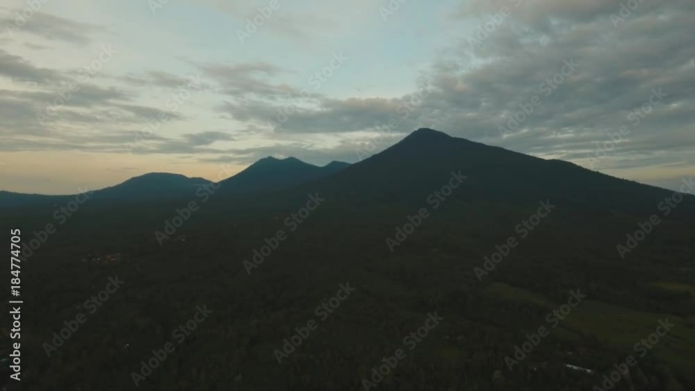 Aerial view of town near the mountain, landscape with sky and clouds at sunset, Bali,Indonesia. Slopes of the mountains are covered with forest in Asia. 4K video. Travel concept. Aerial footage. Aerial view of town near the mountain, landscape with sky and clouds at sunset, Bali,Indonesia. Slopes of the mountains are covered with forest in Asia. 4K video. Travel concept. Aerial footage.