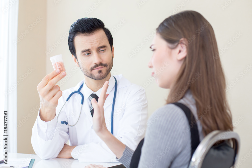Doctor holding medicine showing to patient. People with medical concept.