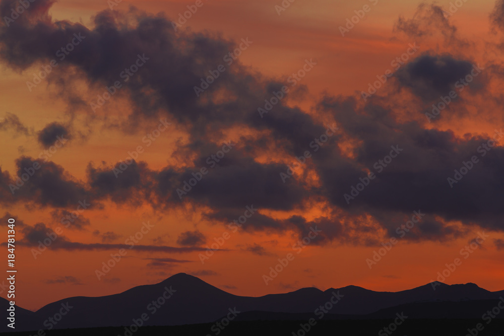 Sunset and sunrise. Orange and red colors. rock area. Volcanic area in Lanzarote national park. Mountain silhouette