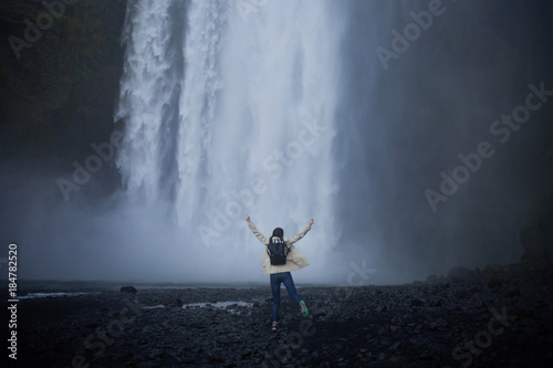 girl runs to the skogafoss waterfall