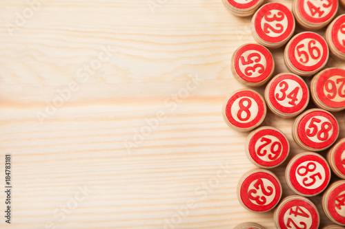 Bingo lotto on wooden background with copy space. Balls with bingo numbers. Flat lay.