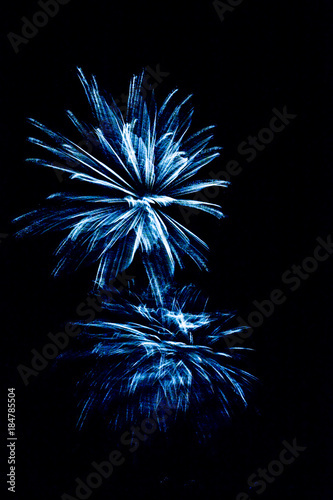 Bright ded and yellow fireworks celebrating New year on black background