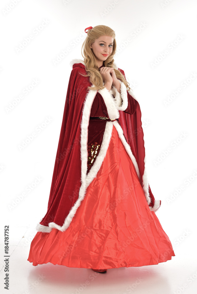 full length portrait of pretty blonde lady wearing red and white christmas inspired costume gown, standing pose on white background. full length portrait of pretty blonde lady wearing red and white christmas inspired costume gown, standing pose on white background.