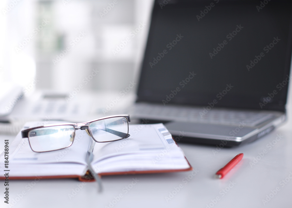 Office table with blank notepad and laptop Office table with blank notepad and laptop
