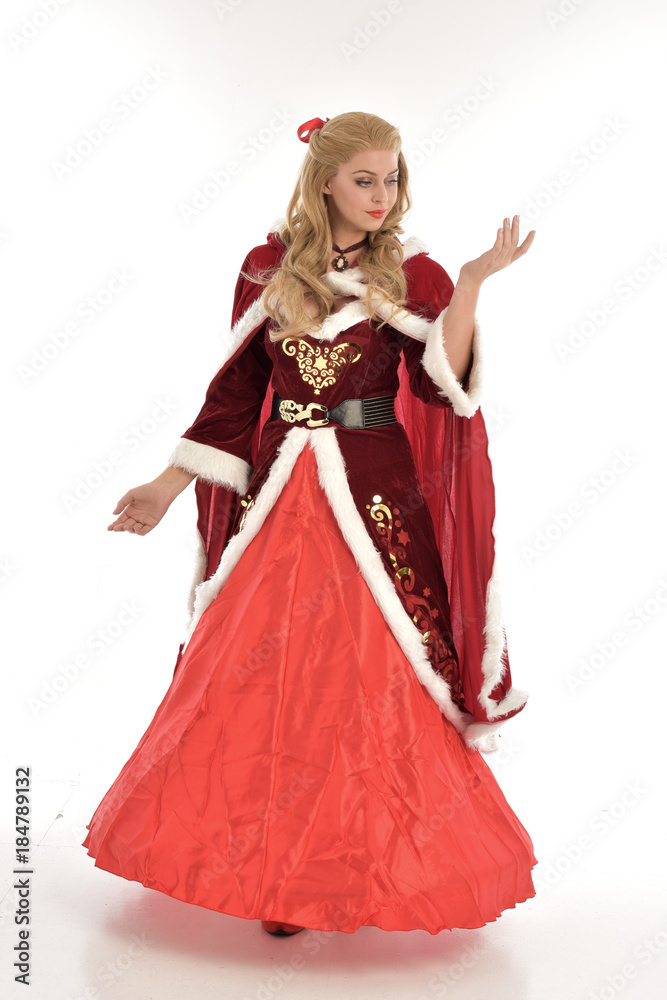 full length portrait of pretty blonde lady wearing red and white christmas inspired costume gown, standing pose on white background. full length portrait of pretty blonde lady wearing red and white christmas inspired costume gown, standing pose on white background.