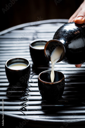 Closeup of delicious sake in black ceramics on black table