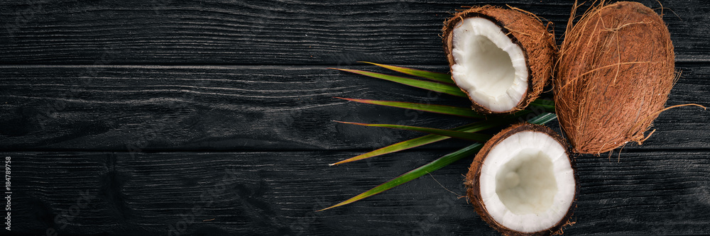 Coconut on a wooden background. Tropical fruits and nuts. Top view. Free space for text. Coconut on a wooden background. Tropical fruits and nuts. Top view. Free space for text.