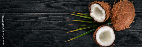 Coconut on a wooden background. Tropical fruits and nuts. Top view. Free space for text.