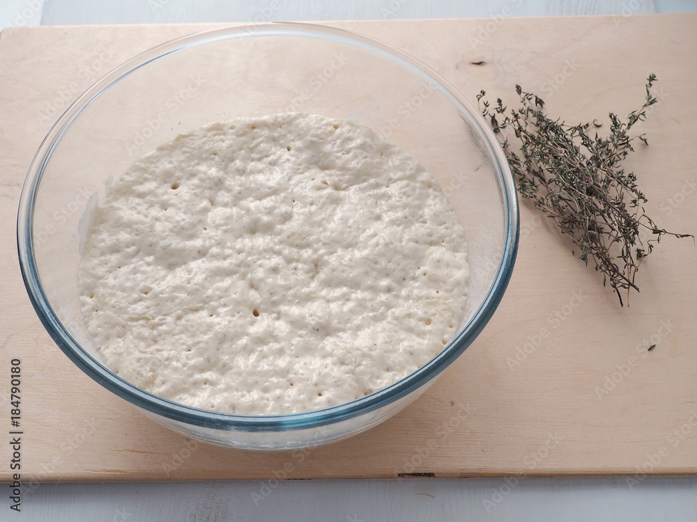 Cooking process. Large bowl with dough leaven. Preparing yeast dough for buns, pastries or pizza. Close up image.