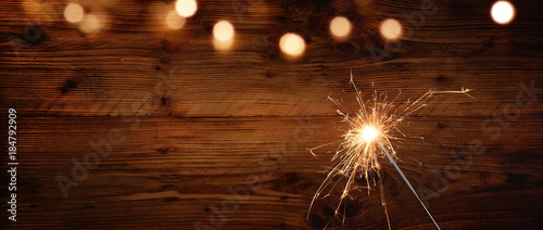 Rustic wooden wall with sparkler and bokeh photo
