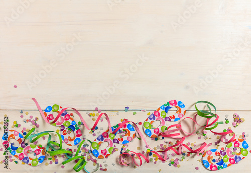 Carnival confetti and serpentines on white background, top niew