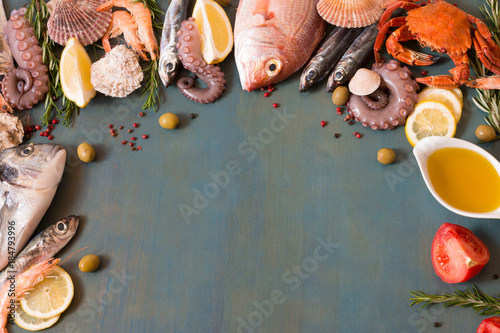 Appetizing seafood and fish lay frame on blue background.