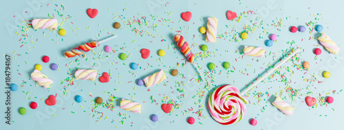 Colorful candies on blue background, top view photo