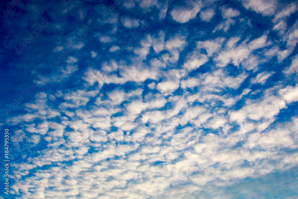 Bright blue sky with shallow curly clouds background
