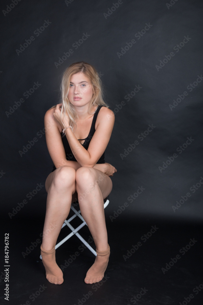 Frau im Body auf Stuhl im Fotostudio
