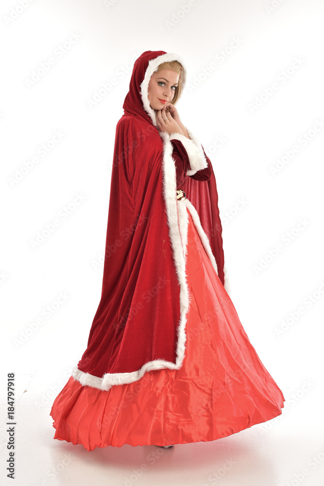 full length portrait of pretty blonde lady wearing red and white christmas inspired costume gown, standing pose on white background.