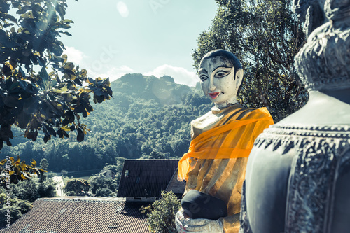 The Buddha statue holding monk's alms bowl at Wat Pilok Temple in Thong Pha Phum National Park, Kanchanaburi province, Thailand photo