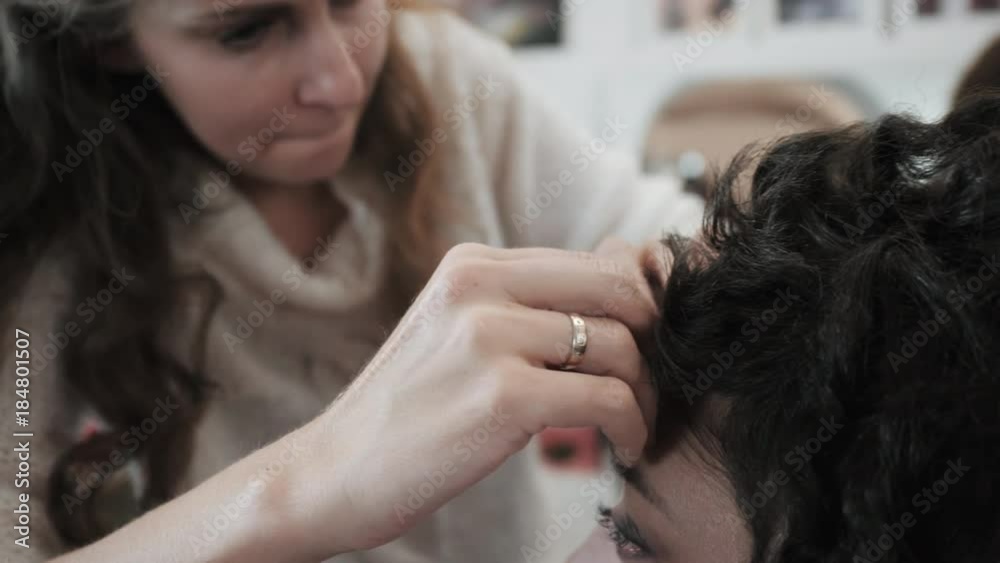 Hairstylist makes styling a girl with curly hair. Stylist. Beauty saloon. Woman in a beauty salon. Stacking. Hairdresser at work. A stylist makes a haircut (curls) for a girl. Slow motion Hairstylist makes styling a girl with curly hair. Stylist. Beauty saloon. Woman in a beauty salon. Stacking. Hairdresser at work. A stylist makes a haircut (curls) for a girl. Slow motion