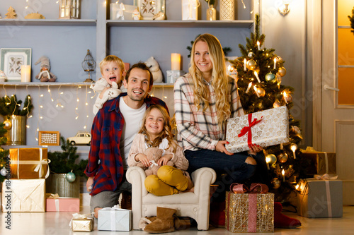 New Year's picture of happy family on background of Christmas decorations, pine