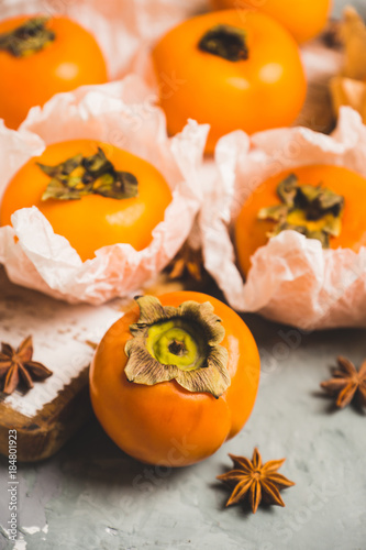 Fresh persimmon fruit on wooden table. Selective focus. Shallow depth of field.