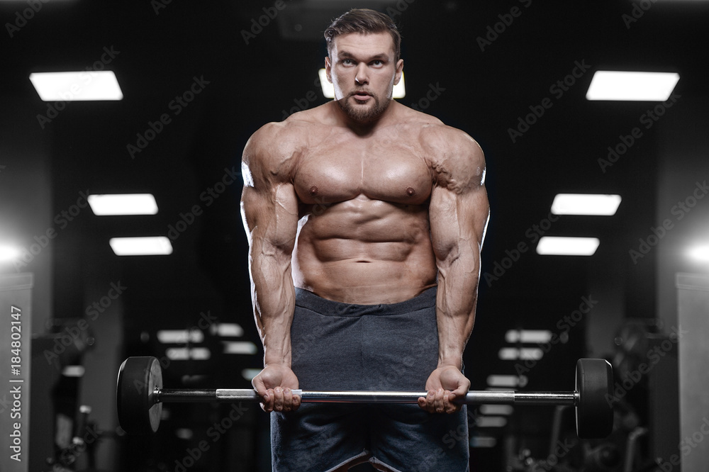 Brutal strong bodybuilder athletic men pumping up muscles with dumbbells. Brutal strong bodybuilder athletic men pumping up muscles with dumbbells.