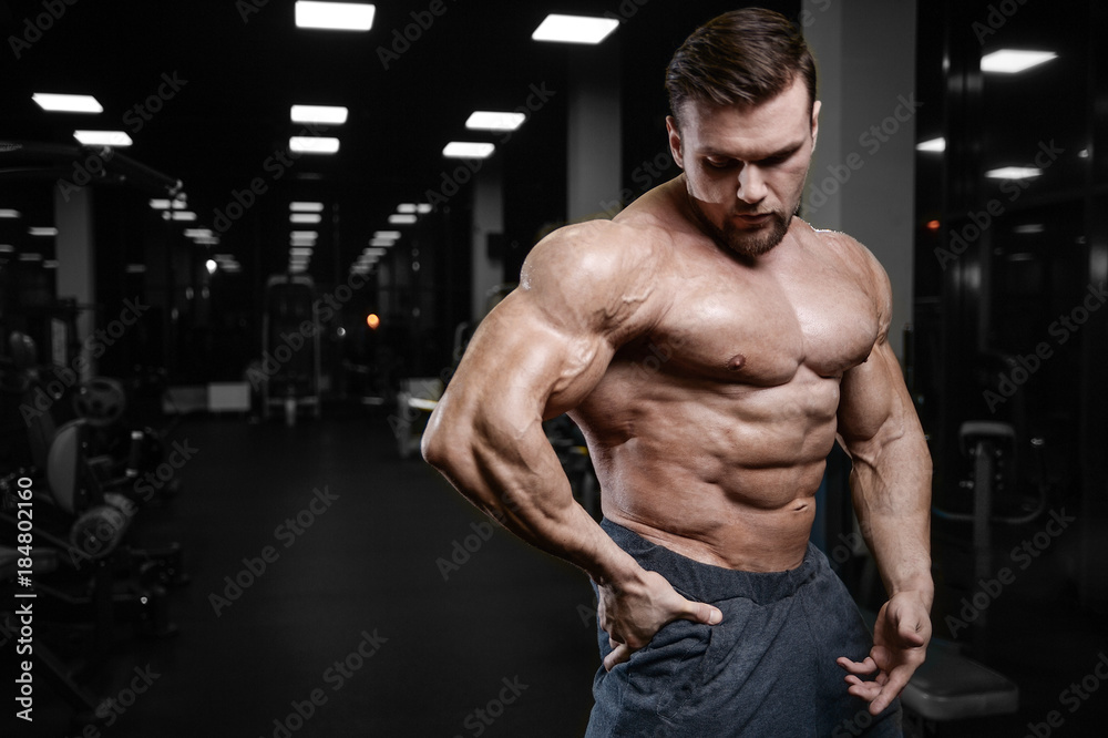 Brutal strong bodybuilder athletic men pumping up muscles with dumbbells.