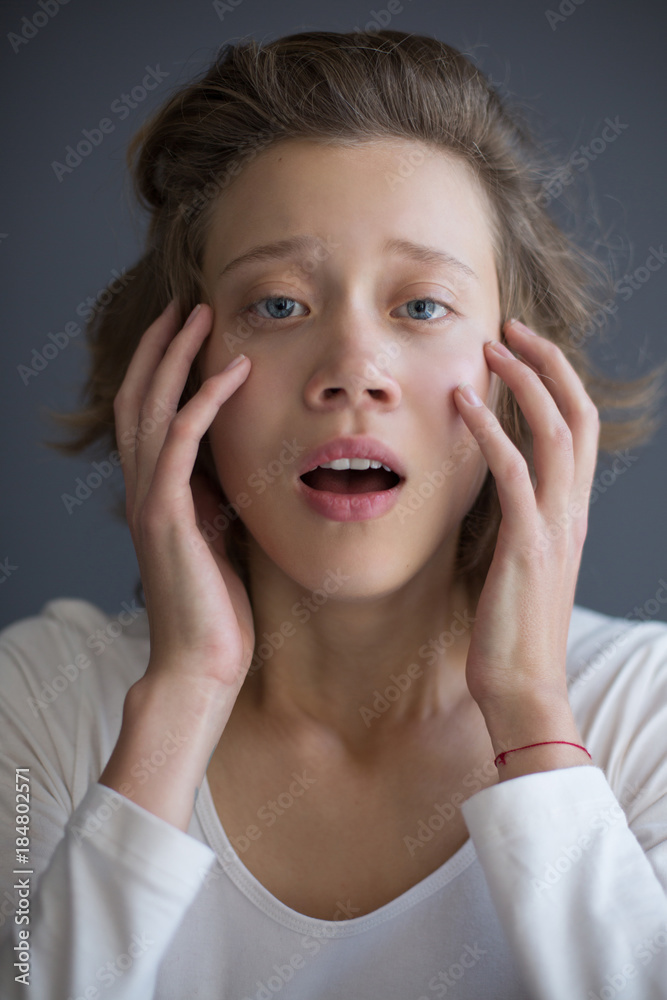 Portrait of young startled lady sadly looking in camera while holding her hands near face isolated Portrait of young startled lady sadly looking in camera while holding her hands near face isolated