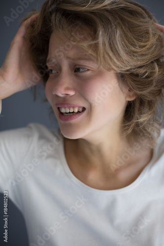 Portrait of young crying woman frightenedly looking aside isolated photo