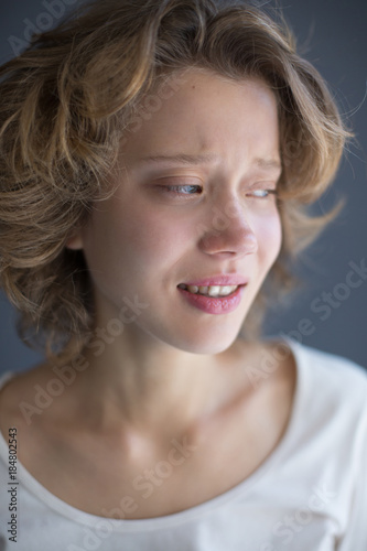 Portrait of crying lady frightenedly looking aside isolated photo