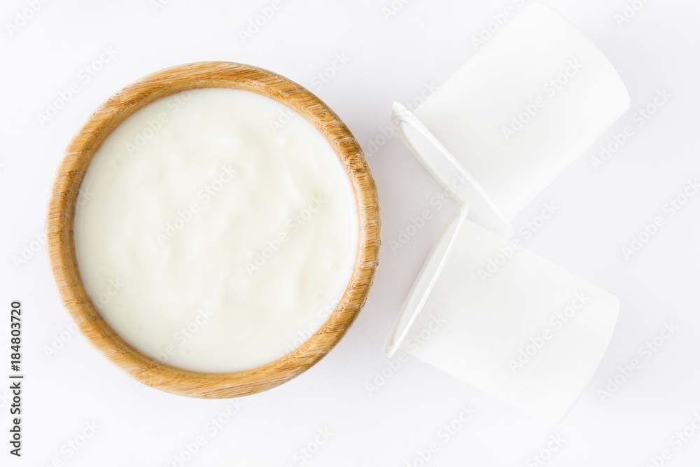 Natural yogurt in wooden bowl isolated on white background. Top view Natural yogurt in wooden bowl isolated on white background. Top view