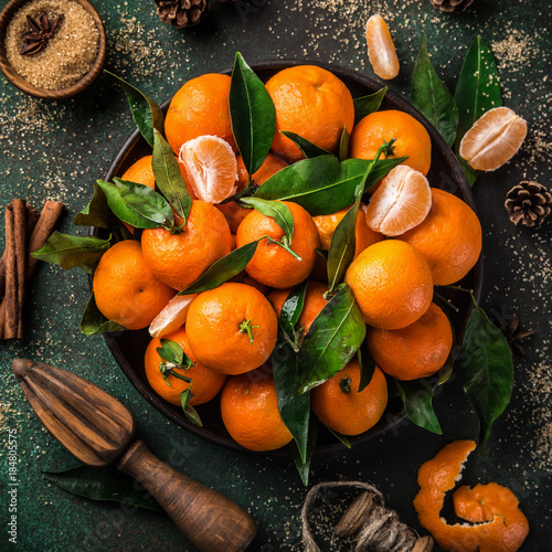 fresh clementines (tangerines) with spices on dark greeen background, top view. Winter or Christmas food concept