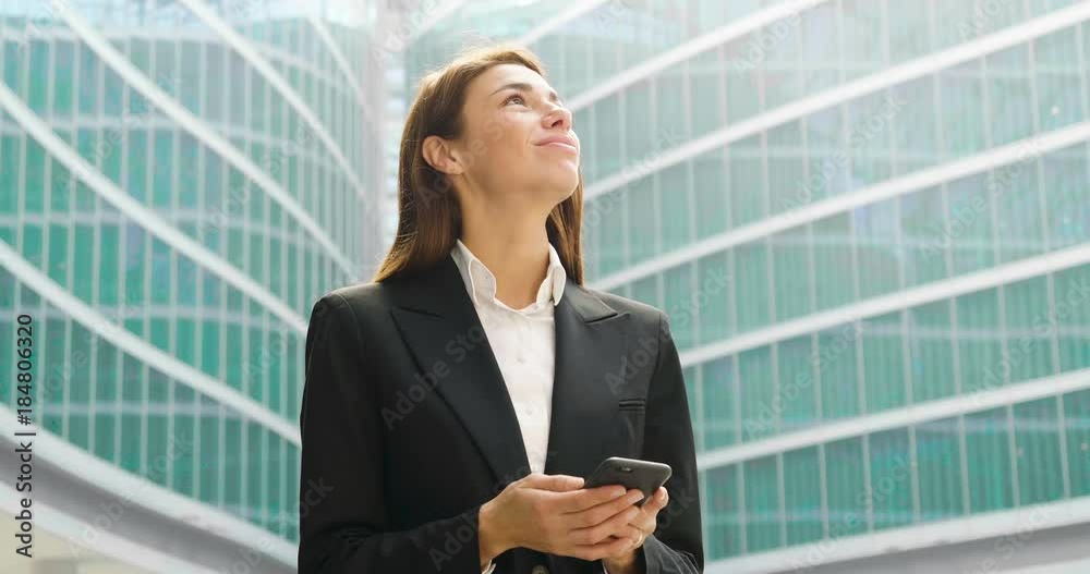A businesswoman in a business suit, using the tablet to control finance and the economy, in the background skyscrapers. A businesswoman in a business suit, using the tablet to control finance and the economy, in the background skyscrapers.