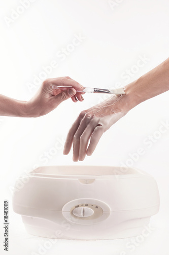 Canvas Print Woman in a nail salon receiving a manicure, she is bathing her hands in paraffin