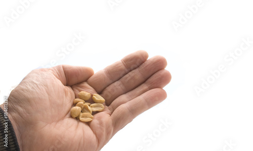 Hand hält gesalzene Erdnüsse, freigestellt auf weissen Hintergrund