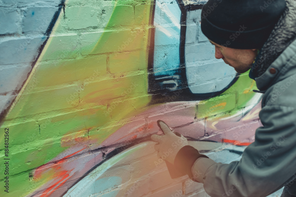 Fototapeta premium man painting colorful graffiti on wall