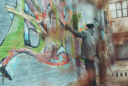 street artist painting colorful graffiti on wall © LIGHTFIELD STUDIOS