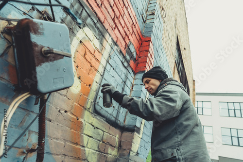 street artist painting colorful graffiti on wall © LIGHTFIELD STUDIOS