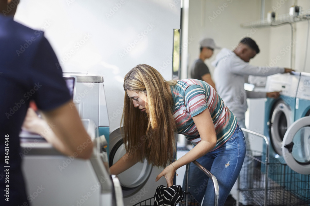 University friends doing laundry at laundromat University friends doing laundry at laundromat