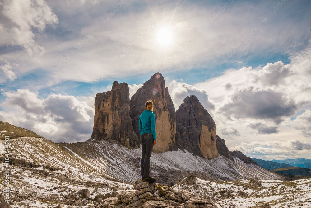 Young female is admiring Tre Cime Di Lavaredo in the Dolomite mountains in Italy