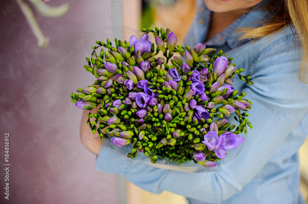 Woman holding a beautiful flower bouquet in purple and green tones for Valentine's day Woman holding a beautiful flower bouquet in purple and green tones for Valentine's day