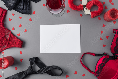 top view of white sheet of paper between underwear and glass of wine