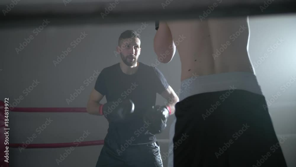Two men training on a boxing ring Two men training on a boxing ring
