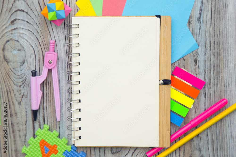 A blank notebook and office supplies