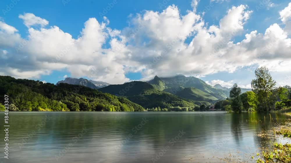 timelapse sunset on Lake with clouds and mountains background. Water reflections. Tuscany. Italy. 4K
