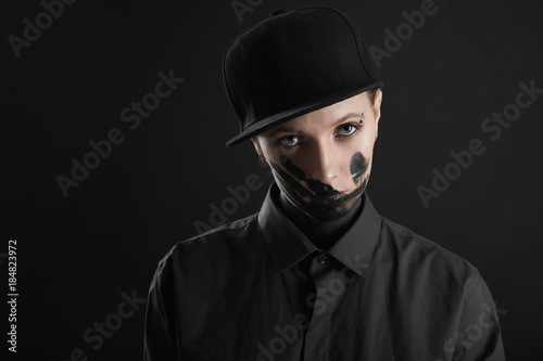 woman in black shirt and hat with black trace of hand on face © kulichok