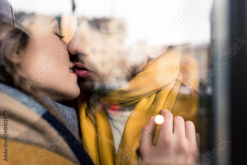 reflective image of kissing couple, closeup